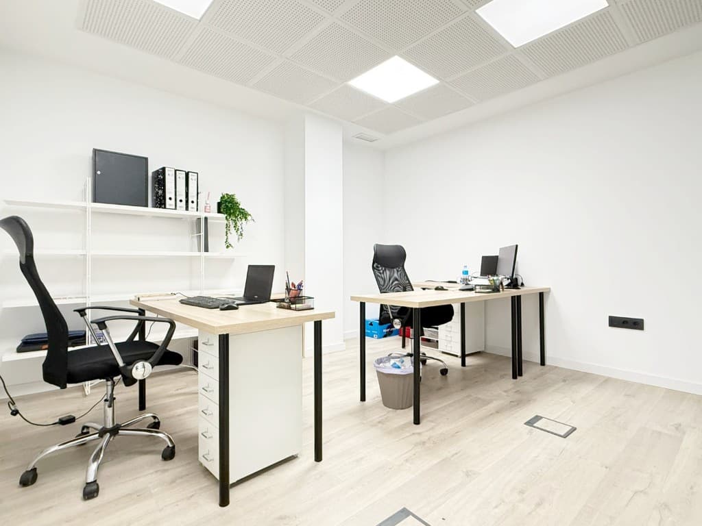 Espacio de trabajo abierto en la oficina AVIRAGO, con zonas equipadas.